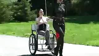 Lesbian wheelchair pony play in a park