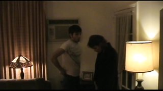 Babe im kurzen schwarzen Kleid versohlt devoten Mann auf Sofa