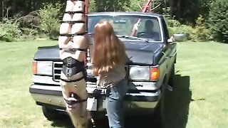 Passionate babe is hanging upside down in front of an old truck