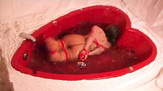 Impresionante chica con grandes tetas está atada en la bañera