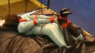 Passionate hogtied chick in latex suit and black boots