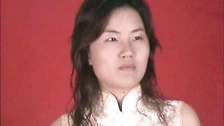 Bounded Asian hottie in white dress is lying on red background