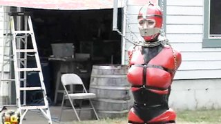 Pretty slave with big tits in tight latex costume walks around on high heels