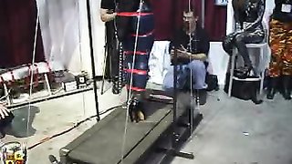 Una chica atada con cinturones se queda quieta en el sex shop local