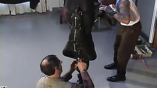 Latex-clad dominatrix uses a vibrator to tease a slave
