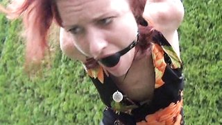 Ballgagged redhead shown completely helpless outdoors